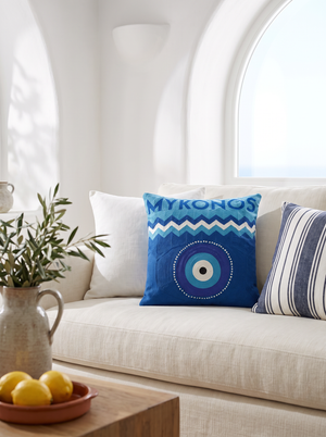 Mykonos Evil Eye needlepoint cushion styled in a whitewashed Greek-island living room