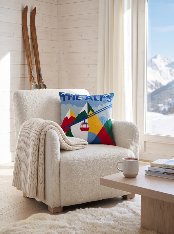 The Alps needlepoint cushion styled in a bright Alpine chalet living room