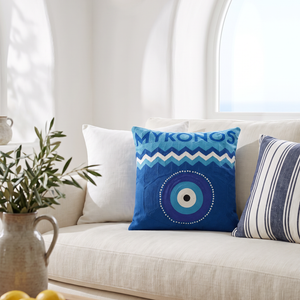 Mykonos Evil Eye needlepoint cushion styled in a whitewashed Greek-island living room