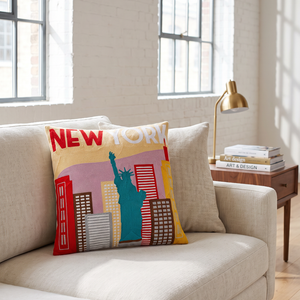 New York City needlepoint cushion styled in a bright loft living room
